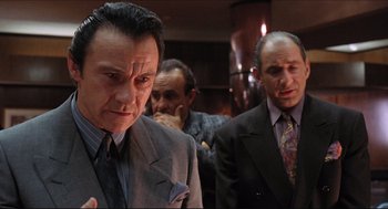 Movie still from “Sister Act” (1992), directed by Emile Ardolino – A group of men standing next to each other in a room; Medium shot, Low angle