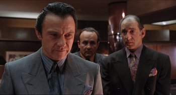 Movie still from “Sister Act” (1992), directed by Emile Ardolino – A group of men standing next to each other in a room; Medium shot, Low angle