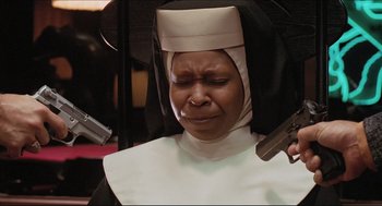 Movie still from “Sister Act” (1992), directed by Emile Ardolino – A nun holding a gun while holding a gun in her hand; Close Up shot, Low angle