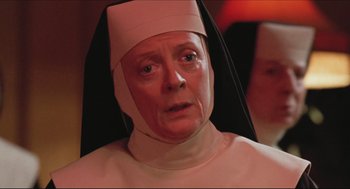 An older woman wearing a nun's outfit and looking sad