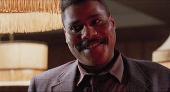 Movie still from “Sister Act” (1992), directed by Emile Ardolino – A person wearing a suit and tie; Close Up shot, Low angle