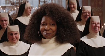 Movie still from “Sister Act” (1992), directed by Emile Ardolino – A woman in a nun's outfit with two other nuns behind her; Close Up shot, Low angle