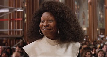 Movie still from “Sister Act” (1992), directed by Emile Ardolino – An older woman with a large afro is smiling for the camera; Close Up shot, Low angle