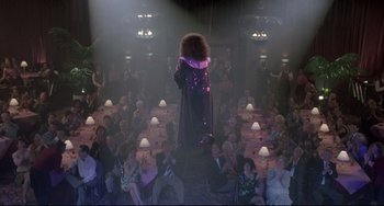 Movie still from “Sister Act 2: Back in the Habit” (1993), directed by Bill Duke – A crowd of people sitting and standing in a room; Wide shot, Overhead angle