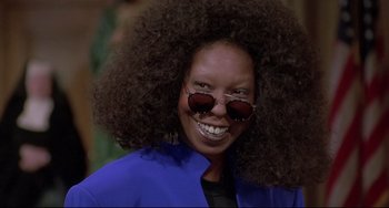 Movie still from “Sister Act 2: Back in the Habit” (1993), directed by Bill Duke – A woman smiles while wearing sunglasses and a blue jacket; Close Up shot, Low angle
