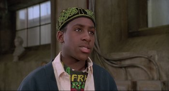 Movie still from “Sister Act 2: Back in the Habit” (1993), directed by Bill Duke – A young man wearing a head scarf and a jacket; Close Up shot, Low angle