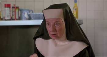 Movie still from “Sister Act 2: Back in the Habit” (1993), directed by Bill Duke – An older woman wearing a nun's outfit in a kitchen; Close Up shot, Low angle