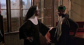 Movie still from “Sister Act 2: Back in the Habit” (1993), directed by Bill Duke – A nun and a boy are talking to each other in a room; Medium shot, Over the shoulder angle
