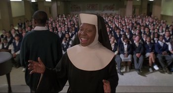 Movie still from “Sister Act 2: Back in the Habit” (1993), directed by Bill Duke – A woman in a nun's outfit standing in front of a group of people; Medium shot, Low angle