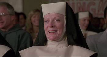 Movie still from “Sister Act 2: Back in the Habit” (1993), directed by Bill Duke – An older woman wearing a nun's outfit and smiling for the camera; Close Up shot, Low angle