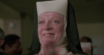 Movie still from “Sister Act 2: Back in the Habit” (1993), directed by Bill Duke – An older woman wearing a nun's hat and smiling; Close Up shot, Low angle