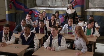 Movie still from “Sister Act 2: Back in the Habit” (1993), directed by Bill Duke – A group of people sitting at a table in a classroom; Wide shot, High angle