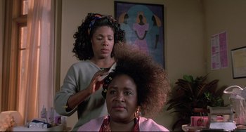 Movie still from “Sister Act 2: Back in the Habit” (1993), directed by Bill Duke – A woman is getting her hair combed by another woman; Close Up shot, Low angle