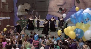 Movie still from “Sister Act 2: Back in the Habit” (1993), directed by Bill Duke – A group of people dressed as nuns performing on a stage; Extreme Wide shot, High angle