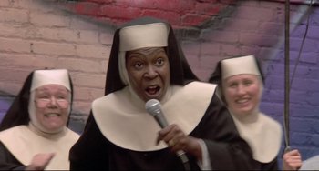Movie still from “Sister Act 2: Back in the Habit” (1993), directed by Bill Duke – A woman dressed as a nun holding a microphone; Close Up shot, High angle