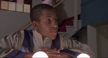 Movie still from “Sister Act 2: Back in the Habit” (1993), directed by Bill Duke – A young man sitting in front of a staircase; Close Up shot, Low angle