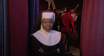 Movie still from “Sister Act 2: Back in the Habit” (1993), directed by Bill Duke – A woman dressed as a nun standing in front of a group of people; Close Up shot, High angle