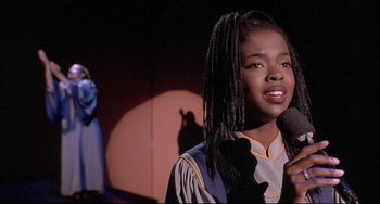 Movie still from “Sister Act 2: Back in the Habit” (1993), directed by Bill Duke – A woman with a microphone in her hand; Close Up shot, High angle