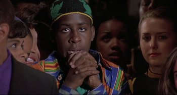 Movie still from “Sister Act 2: Back in the Habit” (1993), directed by Bill Duke – A young man and a young woman sitting in front of each other with their hands clasped together; Close Up shot, Low angle