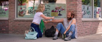 Movie still from “Sisters” (2015), directed by Jason Moore – A man and a woman sitting on the sidewalk; Medium shot, Over the shoulder angle