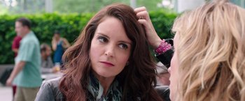 Movie still from “Sisters” (2015), directed by Jason Moore – A person brushing her brown hair; Close Up shot, Over the shoulder angle