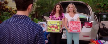 Movie still from “Sisters” (2015), directed by Jason Moore – Two women standing next to each other in front of a car; Medium shot, Over the shoulder angle