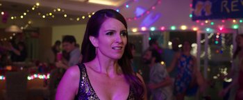 Movie still from “Sisters” (2015), directed by Jason Moore – A beautiful woman in a purple dress standing in front of a crowd; Close Up shot, Over the shoulder angle