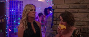 Movie still from “Sisters” (2015), directed by Jason Moore – Two women are talking in front of a brick wall; Medium shot, Over the shoulder angle