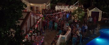 Movie still from “Sisters” (2015), directed by Jason Moore – A group of people standing in a yard at night; Extreme Wide shot, High angle