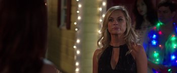 Movie still from “Sisters” (2015), directed by Jason Moore – A woman standing in front of a building with lights; Close Up shot, Over the shoulder angle