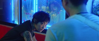 A young woman sitting in front of a fish tank