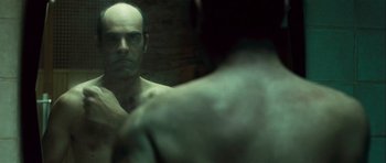 Movie still from “Sleep Tight” (2011), directed by Jaume Balagueró – A man looking at himself in the mirror; Close Up shot, Over the shoulder angle