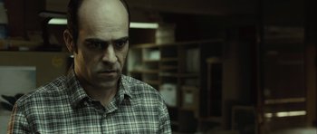 Movie still from “Sleep Tight” (2011), directed by Jaume Balagueró – A man with a bald head is looking at the camera; Close Up shot, Over the shoulder angle