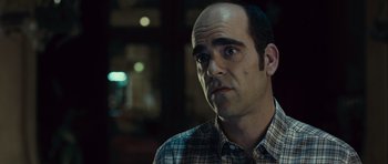 Movie still from “Sleep Tight” (2011), directed by Jaume Balagueró – A man in a plaid shirt is looking to his left; Close Up shot, Over the shoulder angle