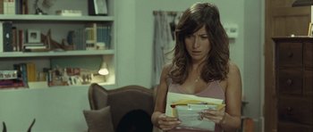 Movie still from “Sleep Tight” (2011), directed by Jaume Balagueró – A woman is holding papers in her hands; Medium shot, Over the shoulder angle