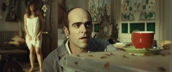 Movie still from “Sleep Tight” (2011), directed by Jaume Balagueró – A man with a bald head looking at something in the distance; Close Up shot, Low angle
