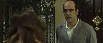 Movie still from “Sleep Tight” (2011), directed by Jaume Balagueró – A man in a gray jacket and white shirt looking at a woman in a gray jacket; Close Up shot, Over the shoulder angle
