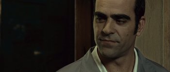 Movie still from “Sleep Tight” (2011), directed by Jaume Balagueró – A person wearing a suit; Close Up shot, Low angle