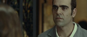 Movie still from “Sleep Tight” (2011), directed by Jaume Balagueró – A person wearing a suit and tie; Close Up shot, Over the shoulder angle