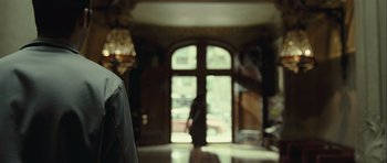 Movie still from “Sleep Tight” (2011), directed by Jaume Balagueró – A person standing in front of an arched doorway; Medium shot, Over the shoulder angle