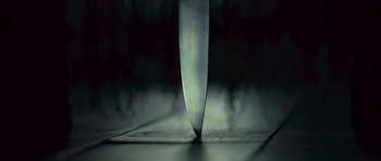 Movie still from “Sleep Tight” (2011), directed by Jaume Balagueró – A large knife on top of a wooden table; Extreme Close Up shot, Overhead angle