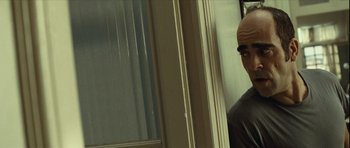 Movie still from “Sleep Tight” (2011), directed by Jaume Balagueró – A man standing in front of a window with his eyes closed; Close Up shot, Over the shoulder angle