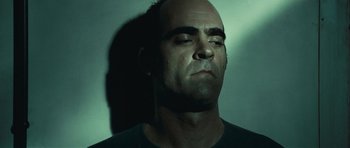 Movie still from “Sleep Tight” (2011), directed by Jaume Balagueró – A man with his eyes wide open and his head tilted to the side; Close Up shot, Low angle
