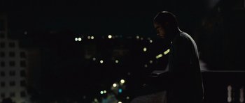 Movie still from “Sleep Tight” (2011), directed by Jaume Balagueró – A man standing in the middle of the night looking at the lights; Medium shot, Low angle