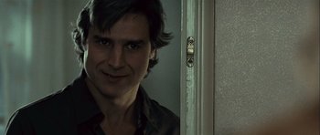 Movie still from “Sleep Tight” (2011), directed by Jaume Balagueró – A man's face as he stands in front of a door; Close Up shot, Over the shoulder angle