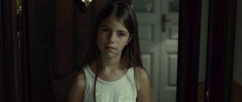 Movie still from “Sleep Tight” (2011), directed by Jaume Balagueró – A young girl with long brown hair wearing a white shirt; Close Up shot, Over the shoulder angle