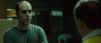 Movie still from “Sleep Tight” (2011), directed by Jaume Balagueró – A man sitting in front of a mirror in a room; Close Up shot, Over the shoulder angle