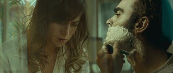 Movie still from “Sleep Tight” (2011), directed by Jaume Balagueró – A man shaving a woman's face in a bathroom; Close Up shot, Over the shoulder angle