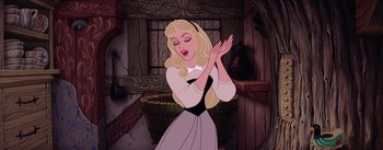 Movie still from “Sleeping Beauty” (1959), directed by Wolfgang Reitherman – A cartoon of a blonde haired woman in a white dress clapping her hands in front of a window; Medium shot, Low angle