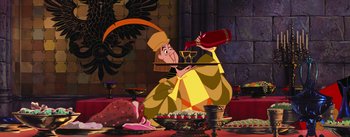 Movie still from “Sleeping Beauty” (1959), directed by Wolfgang Reitherman – A man sitting on the ground holding a wine glass; Wide shot, Overhead angle